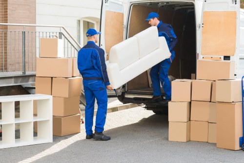 Office desks and filing items being moved through a building with limited access